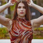Fashionable woman with glasses posing in a colorful top outdoors, Tampa, FL.