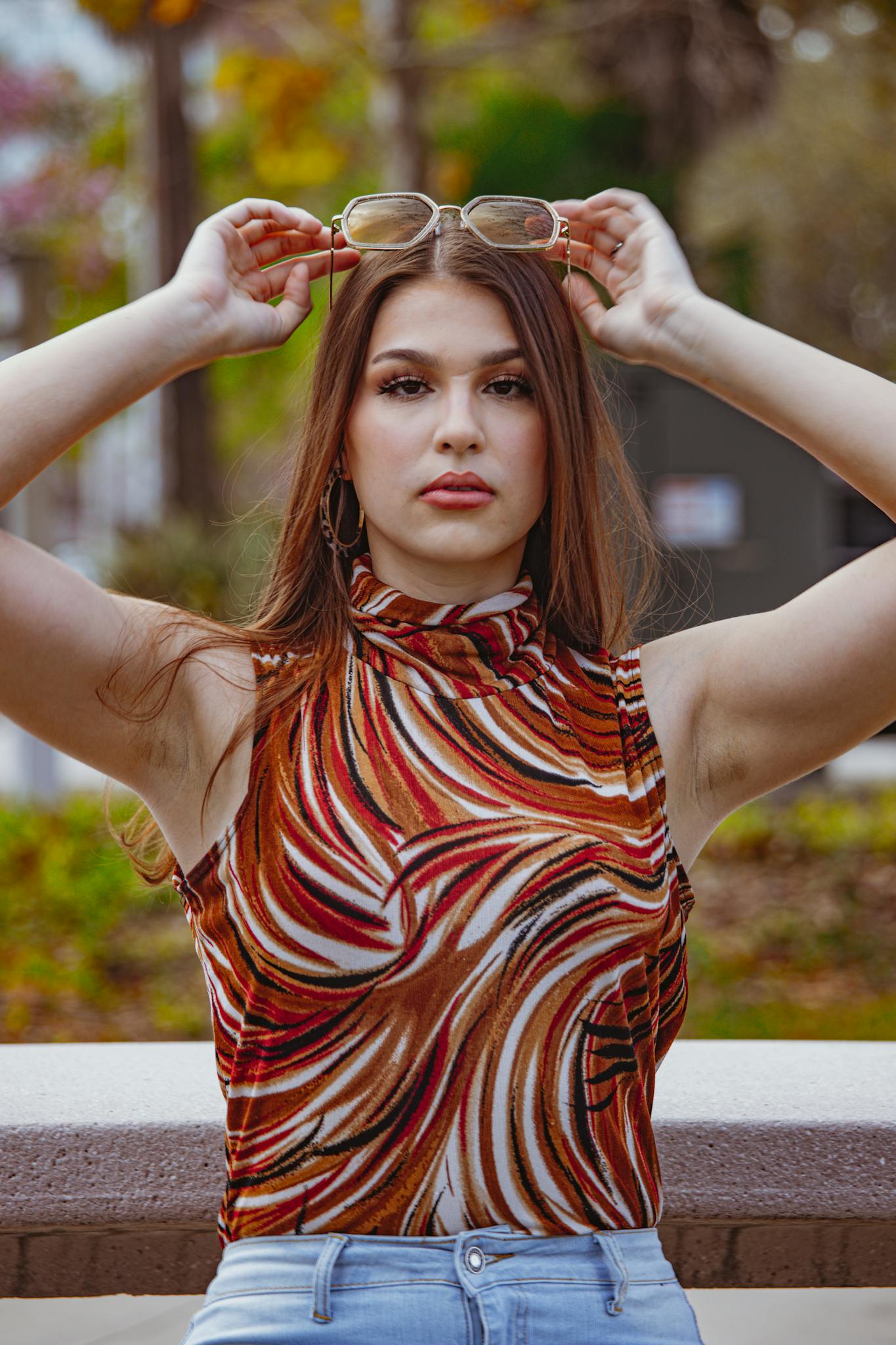 Fashionable woman with glasses posing in a colorful top outdoors, Tampa, FL.