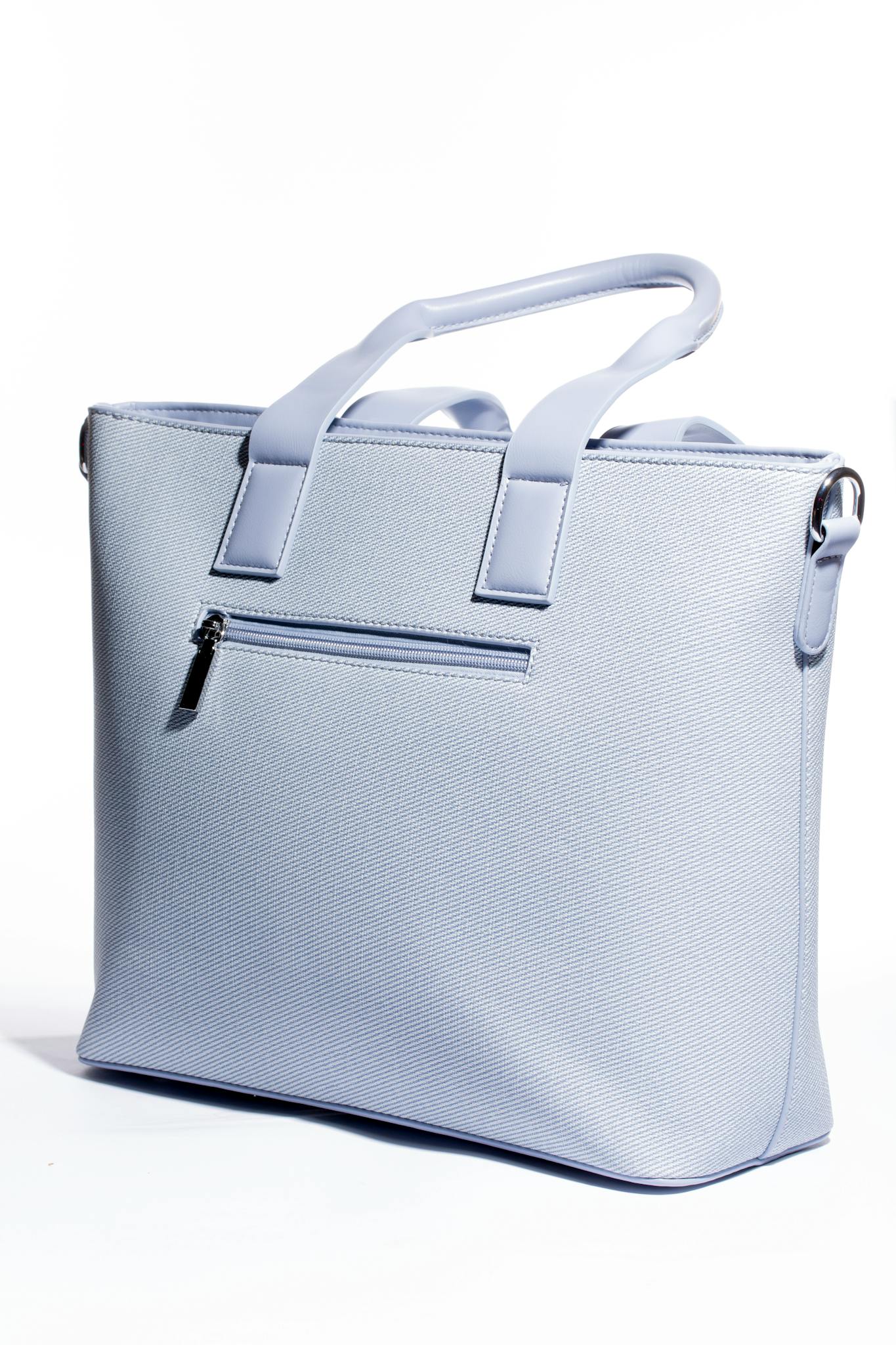 Stylish light blue handbag with textured surface, showcasing modern design. Ideal for fashion shoots.